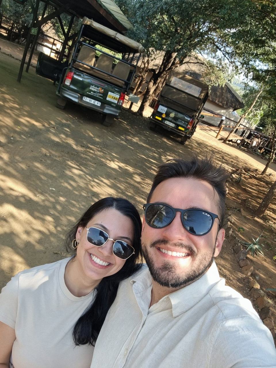 Casal sorridente na base de operações do safári
